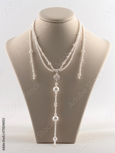 Elegant necklace with white pearls on necklace display.