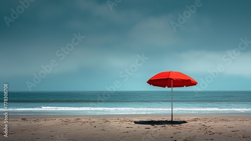 Vibrant red beach umbrella stands out against a serene coastal scene