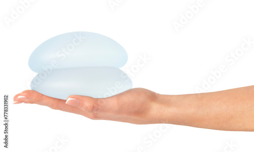Female holding breast implants on hand, isolated