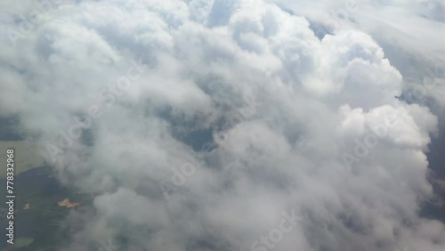 The view from the airplane window. Flying above the blue sky with moving clouds. Traveling on airplane at clear weather day.