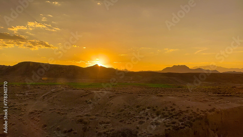 desert sunset, sun setting over rocky hills 