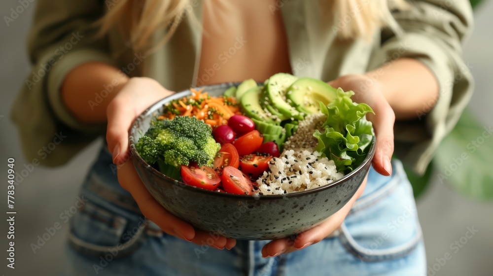 Healthy vegan buddha bowl held by a woman. Close-up shot with selective focus. Health and nutrition concept