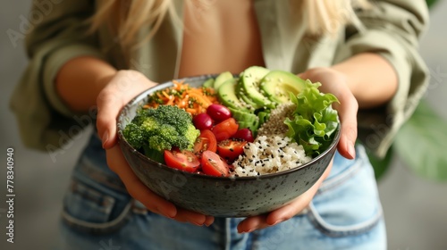 Healthy vegan buddha bowl held by a woman. Close-up shot with selective focus. Health and nutrition concept © ANStudio