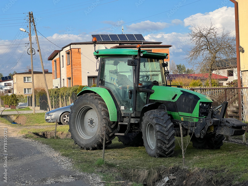 A tractor parked in front of the house, just like a car A tractor parked in front of the house, just like a car