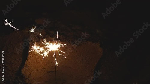 Cold sparklers on sea beach in the dark night.
