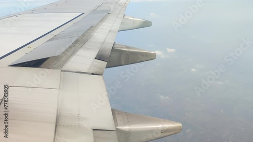 The view from the airplane window. Flying above the blue sky with moving clouds. Traveling on airplane at clear weather day.
