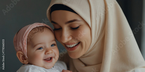 Portrait of Joyful Muslim Mother and Baby Sharing a Laugh. Happy smiling Muslim mother in hijab with her laughing infant, copy space, mother, motherday, motherdayconcept