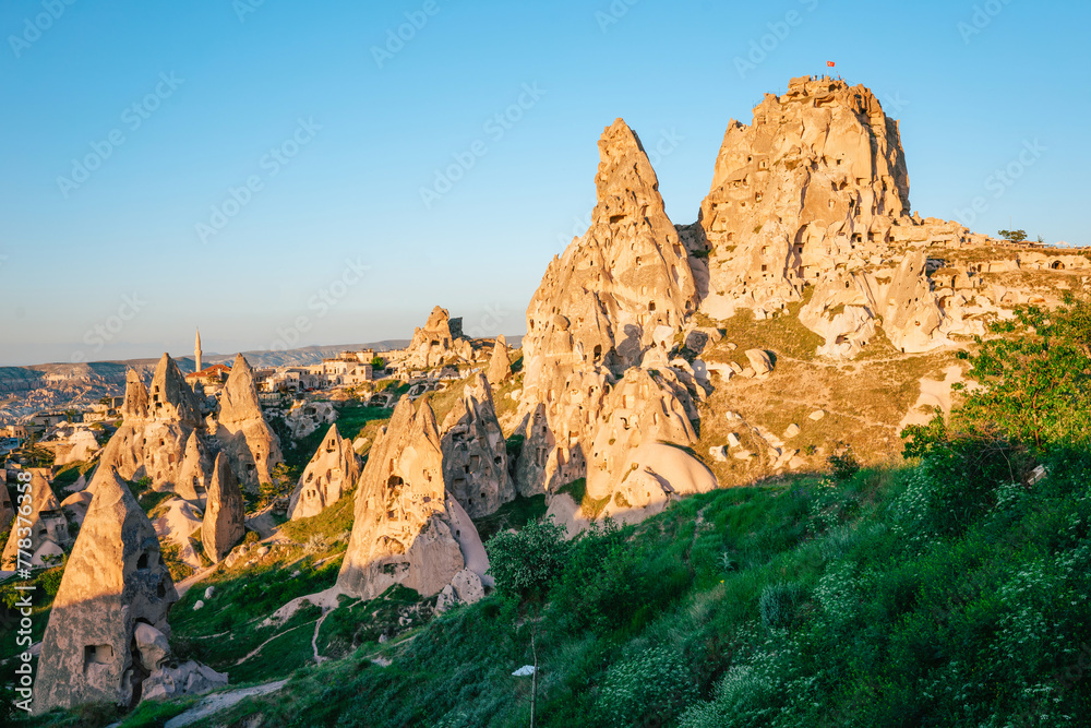 Warm evening light casting a golden hue on the fairy chimneys and Uchisar Castle in Cappadocia