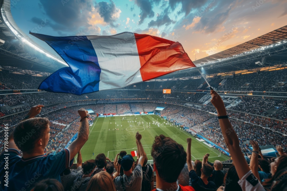 Fototapeta premium A crowd of people are cheering at a stadium, holding a French flag. Football fans or spectators at the championship