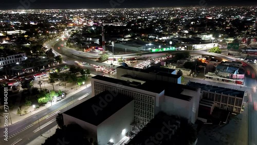 Drone hyperlapse of street intersection with traffic and illuminated buildings at night photo