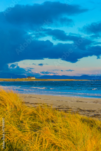 Tiree, Inner Hebrides, Scotland.  A portrait of the beautiful Gott Bay on the Isle of Tiree with blue cloud formation and golden machair.  Vertical.  Space for copy.