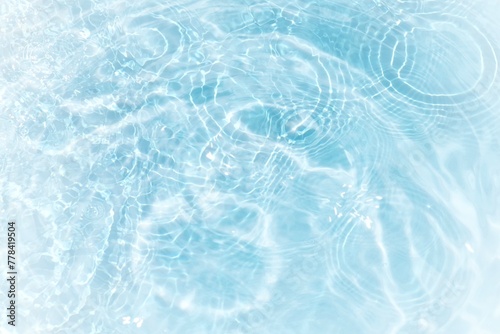 Bluewater waves on the surface ripples blurred. Defocus blurred transparent blue colored clear calm water surface texture with splash and bubbles. Water waves with shining pattern texture background.	