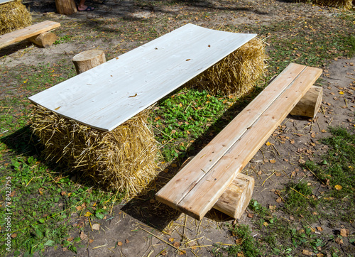 Table and bench made of straw, logs and boards
