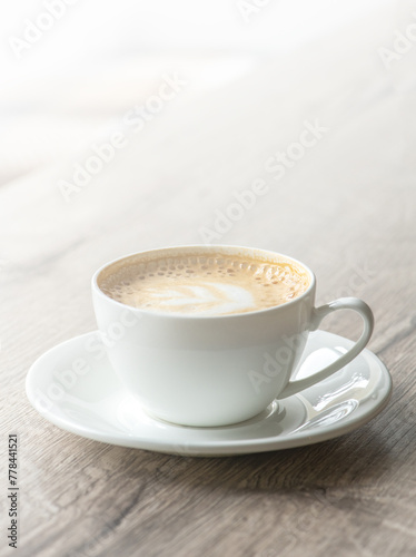Cup of hot cappuccino coffee on table