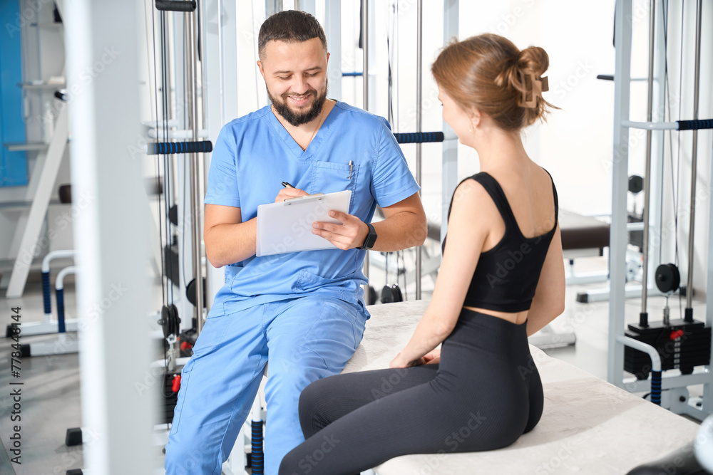 Physiotherapist instructor questions a female patient Physiotherapist instructor questions a female patient