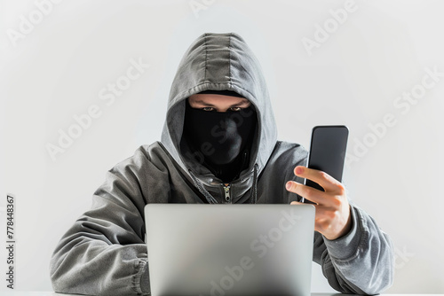 Hacker in black mask using computer and smartphone hacking computer network with viruses. Cyber cybercrime
