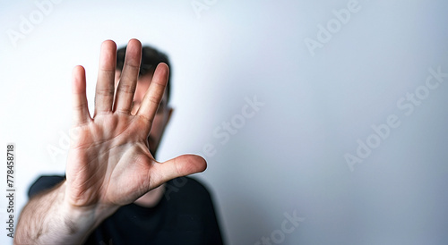 A man making a stop gesture with his hand against a white background. Copy space.