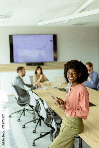 Radiant professional African American woman leading a creative team meeting in a modern office