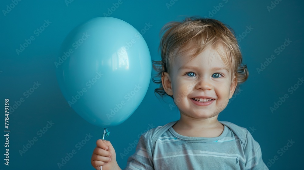 Little boy hugging blue balloon on pastel blue background Little boy hugging blue balloon on pastel blue background