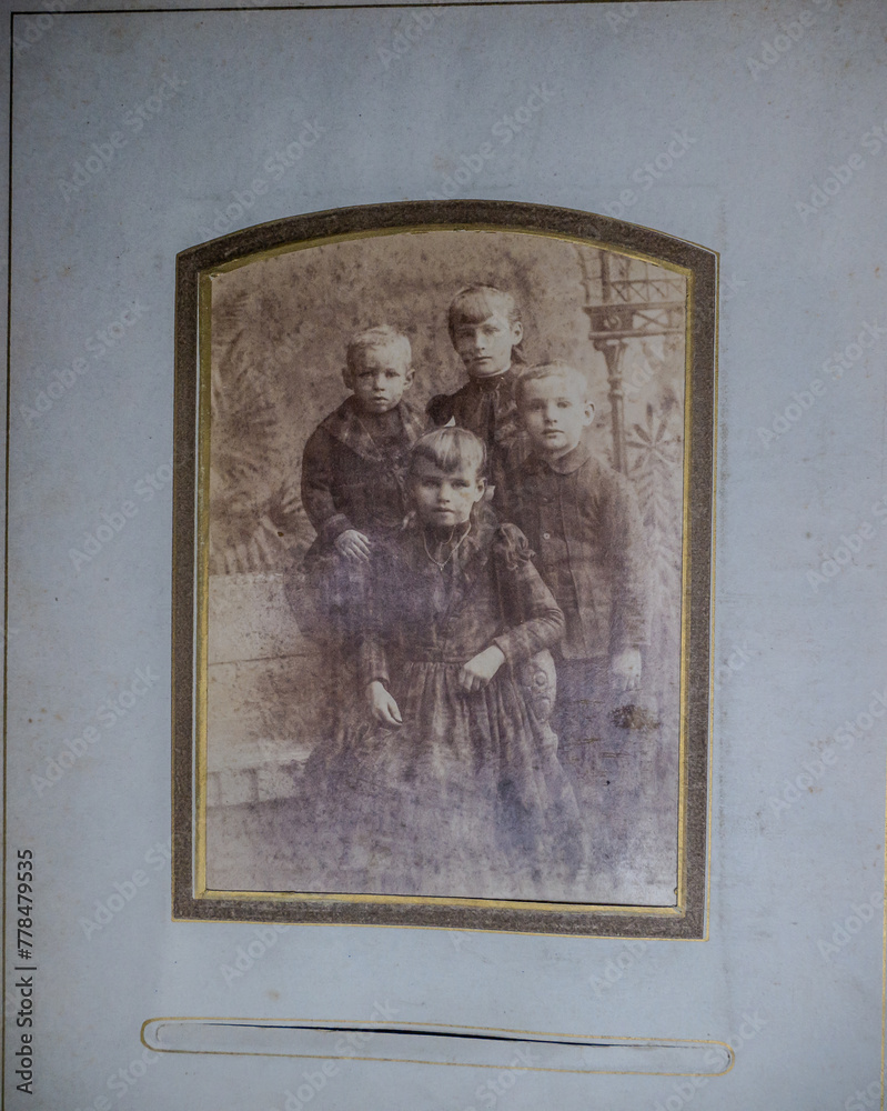Old 1800s photo of four children posing portrait
