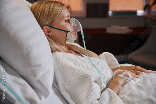 Hospitalized adult woman receiving intravenous therapy in inpatient facility