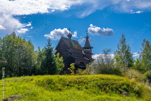 die Holzkirche in Nikolskoje im Gebiet Leningrad bei Sankt Petersburg in einer schönen russischen Landschaft photo