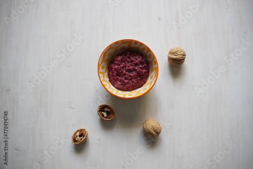 sweet urbech dessert made of nuts with berries in a bowl on wooden table photo