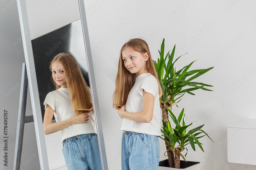 Child Girl Brushing Hair in Mirror. Morning preparation before school. Child Girl Brushing Hair in Mirror. Morning preparation before school.