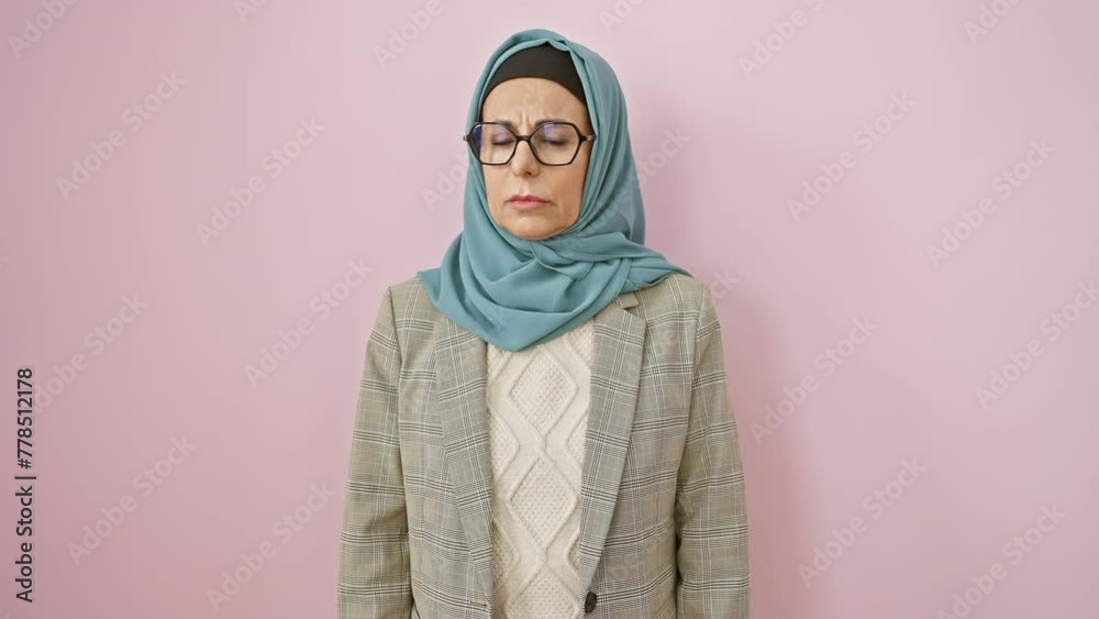 Nervous, skeptical middle-aged hispanic woman in hijab frowning in upset melancholy over a problem. isolated on a pink background. negative emotions oozing.