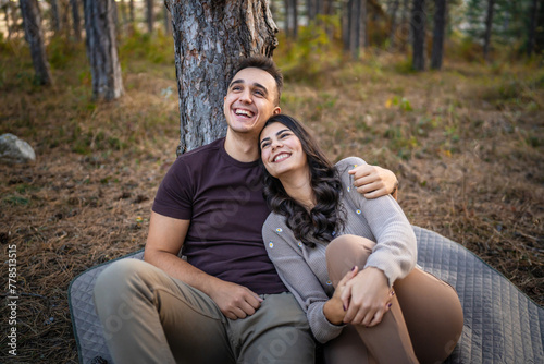 Man and woman young adult couple in love sit in nature