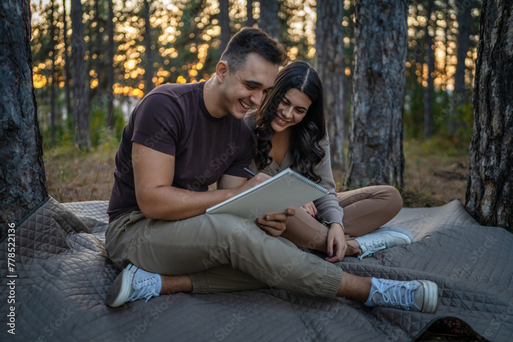 Man and woman young adult couple in nature hold and draw in nature Man and woman young adult couple in nature hold and draw in nature