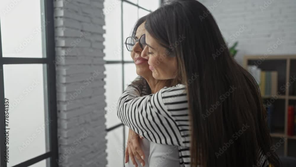 A warm embrace between a smiling mother and daughter in a cozy living room, showcasing love and family bond. A warm embrace between a smiling mother and daughter in a cozy living room, showcasing love and family bond.
