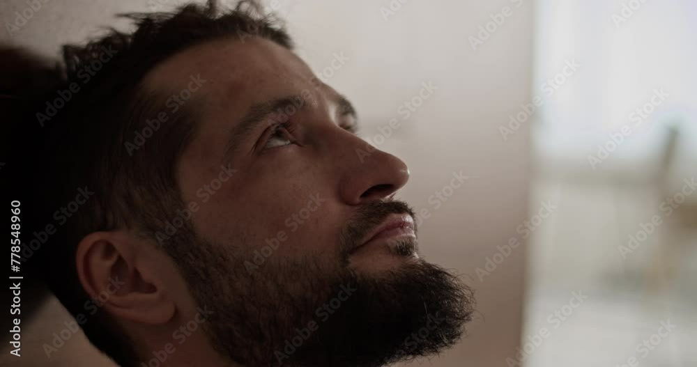 Pensive bearded man looking up against blurred background Pensive bearded man looking up against blurred background