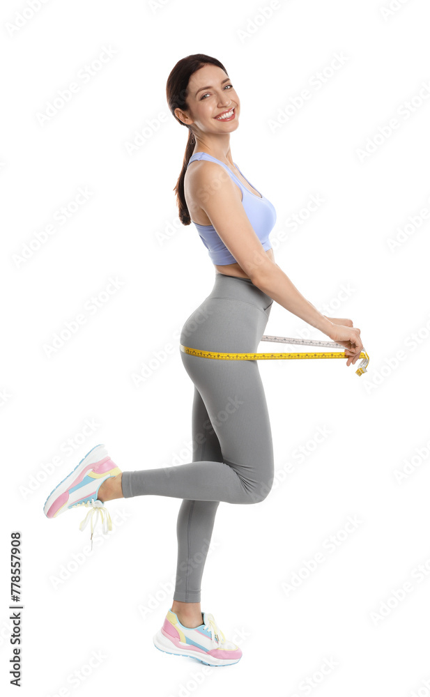 Happy young woman with measuring tape showing her slim body against white background Happy young woman with measuring tape showing her slim body against white background