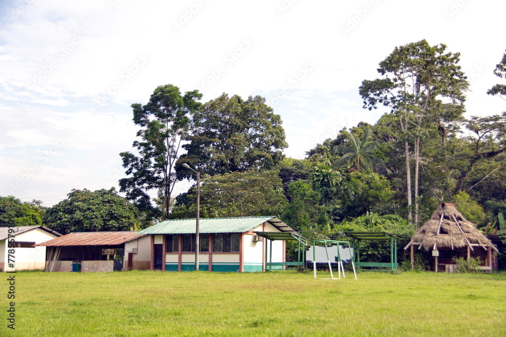 Fototapeta premium Houses and buildings around a large field in Puerto Bolivar, in the Cuyabeno Wildlife Reserve, outside of Lago Agrio, Ecuador