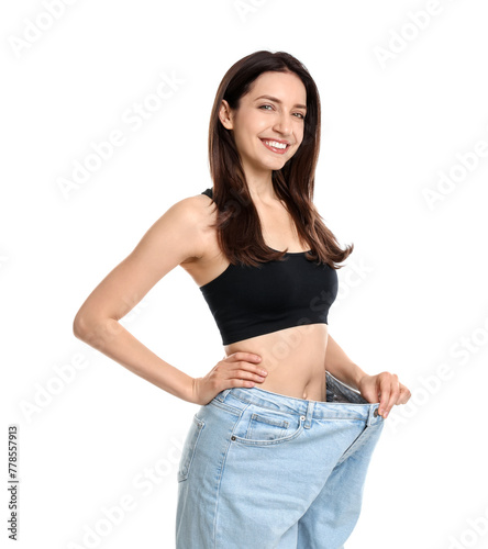 Happy young woman in big jeans showing her slim body on white background