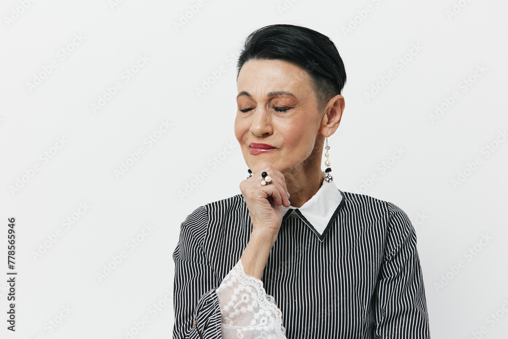 Thoughtful young woman with short hair in a black and white striped shirt looking contemplatively with hand on chin Thoughtful young woman with short hair in a black and white striped shirt looking contemplatively with hand on chin