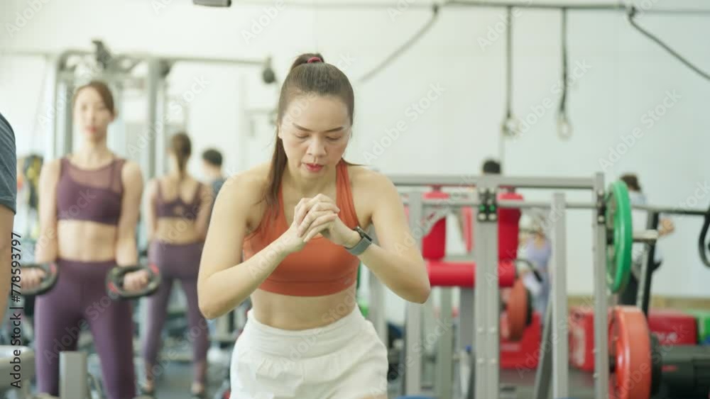 A woman is happily working out at a gym, surrounded by exercise equipment, embodying fitness, health, and an athletic lifestyle A woman is happily working out at a gym, surrounded by exercise equipment, embodying fitness, health, and an athletic lifestyle