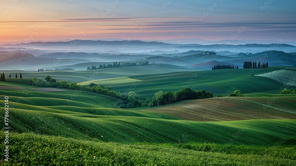 A peaceful countryside landscape at dawn, with rolling hills, a patchwork of farmland, and the first light of day breaking over the horizon.