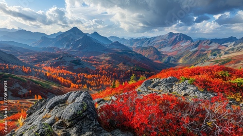 A scenic panorama of a mountain range in the fall, where the play of light and shadow enhances the vivid reds, oranges, and yellows of the foliage.