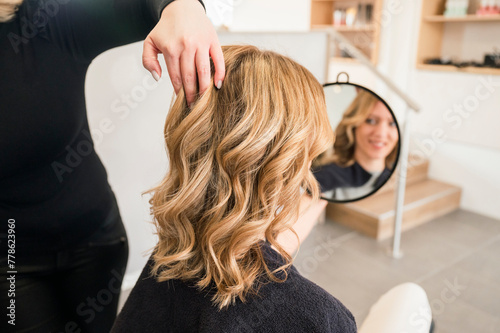 A woman with blonde hair is getting her hair done by a stylist