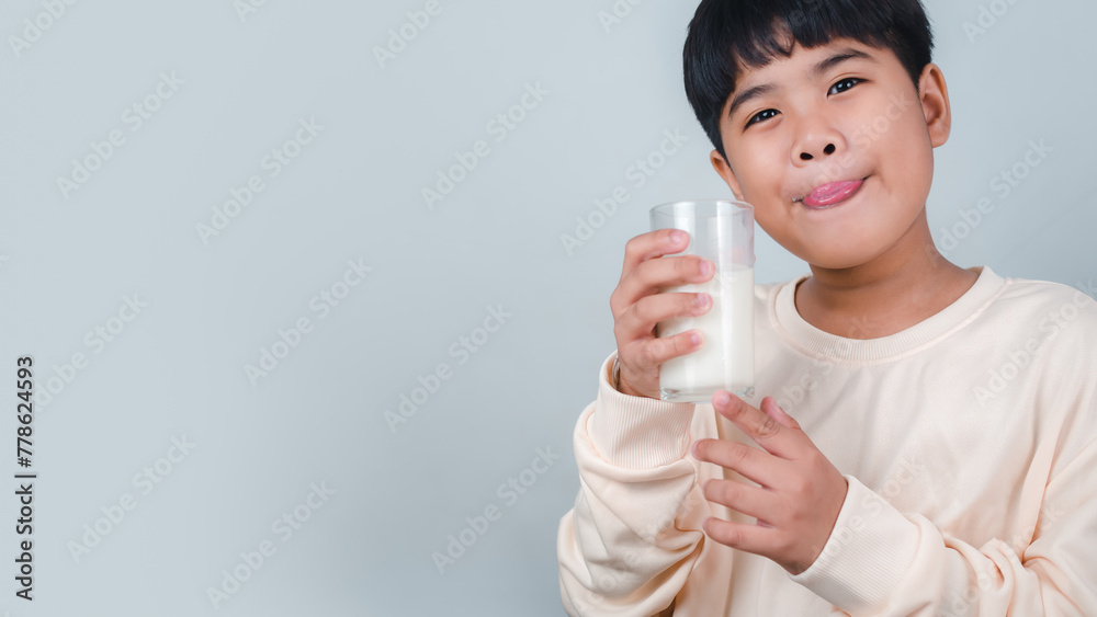 Concept of happy good nutrition, Portrait of a little young handsome kid boy in cream color shirt, Hold drinking milk box mockup, Isolated on white background. Concept of happy good nutrition, Portrait of a little young handsome kid boy in cream color shirt, Hold drinking milk box mockup, Isolated on white background.