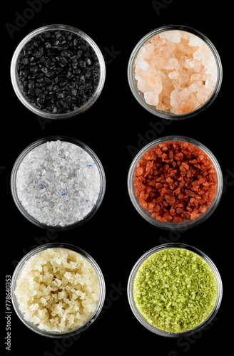 Composition with 6 types of edible salts on a black background. Black salt, Hawaiian volcanic red, Himalayan pink, wasabi, Persian blue and fleur de sel