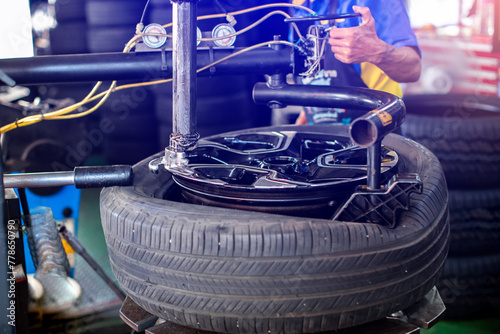 Selective focus to machine do removing car tires from wheel rims. Dismantling tire from rim using special machinery.