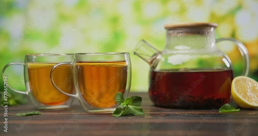organic natural tea brewing in a glass teapot on a wooden table organic natural tea brewing in a glass teapot on a wooden table