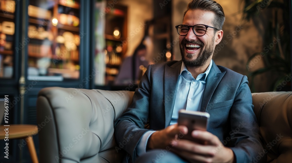 Businessman laugh holding smartphone sit on sofa at cafe coffee shop male Caucasian with beard Businessman laugh holding smartphone sit on sofa at cafe coffee shop male Caucasian with beard