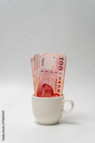 Taiwanese dollar banknote in a cup