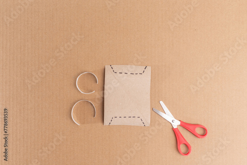 Simple paper crafting idea for kids ,DIY tutorial offers step-by-step instructions. Step 2 involves a card template with square cutouts, set against a brown background. paper ram art project,  photo