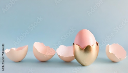 eggshell with pastel pink paint creative copy space on blue background minimal easter holiday concept