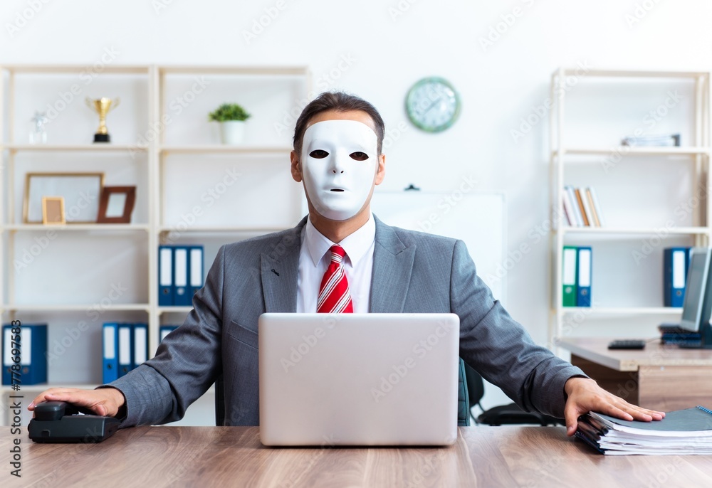 Businessman wearing mask in hypocrisy concept